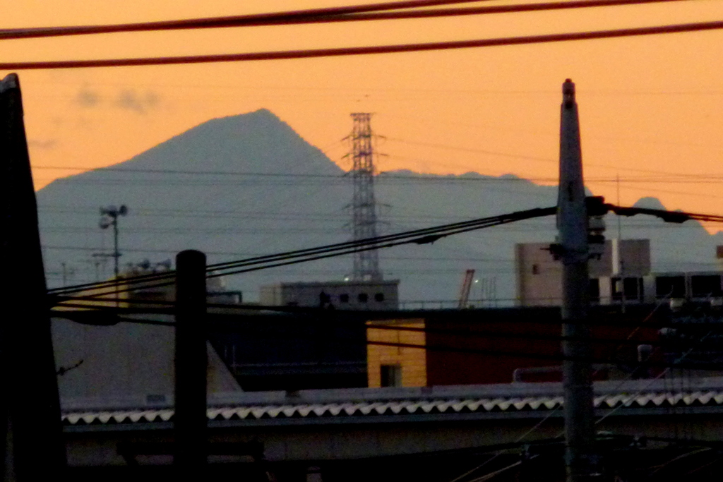 荒川土手の高速下から夕焼けの武甲山のシルエット