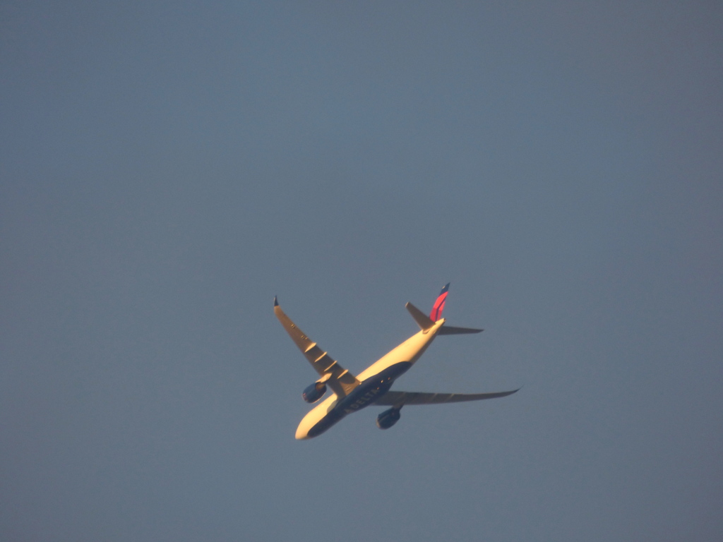 北方面の向かう夕日を浴びる飛行機