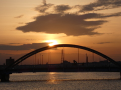 隅田川尾竹橋のアーチに掛かる雲の夕日