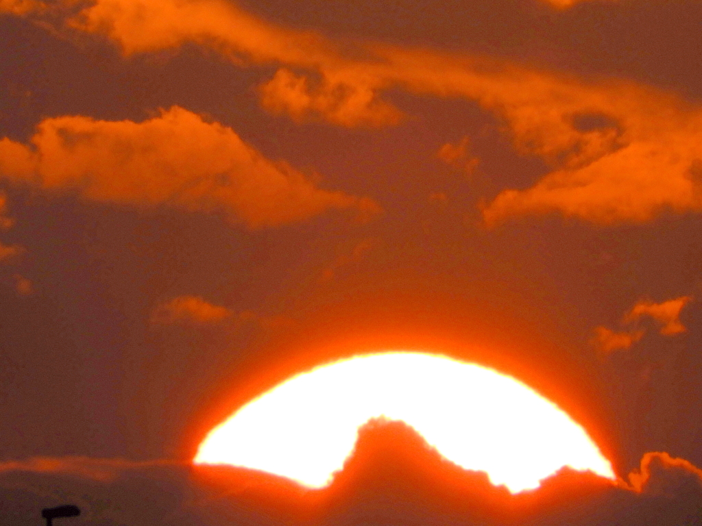 夕雲に隠れる大きな夕日