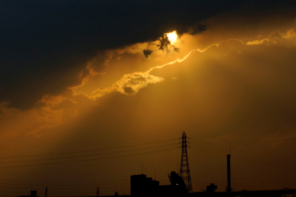 隅田川尾竹橋から黒雲から夕日が下りる風景
