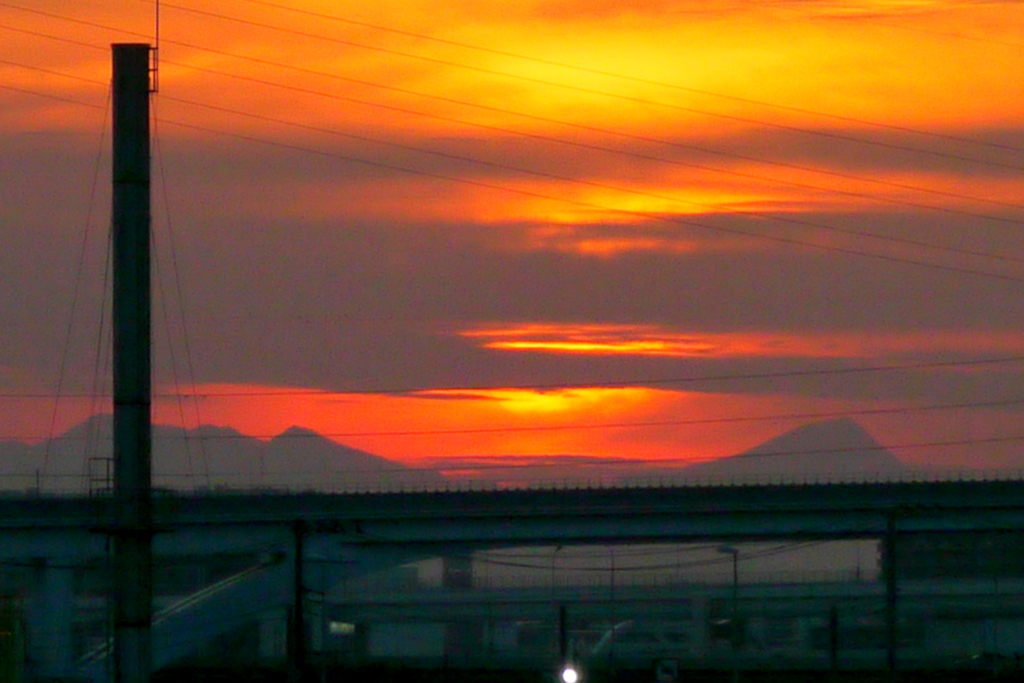 隅田川の煙突の右下の雲被る夕焼け雲と山