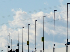 高速の高架上の連なったポールのバックに大きな積雲