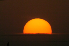水平の雲の中に沈む夕日