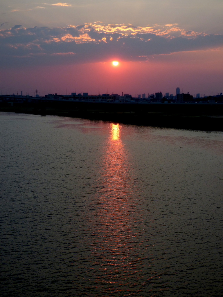 荒川上のUFO雲から顔を出した夕日
