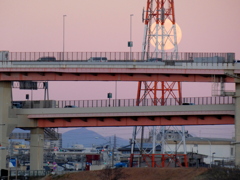 荒川土手から対岸の高速高架下の傘山が見える鉄塔の早朝の満月