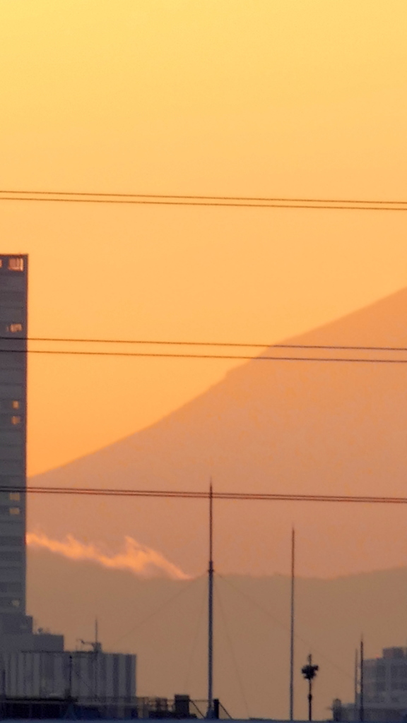 荒川土手からビルの間に見える富士山の裾