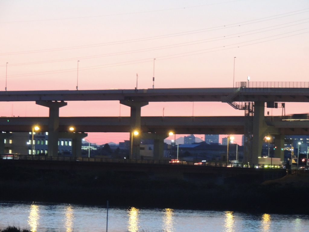 荒川土手の高速道路の高架下の夏至の夕日が落ちる山の夕焼け