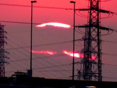 千住新橋から高速道路上の南小太郎山に掛かる雲の中の’22年同日の夕日