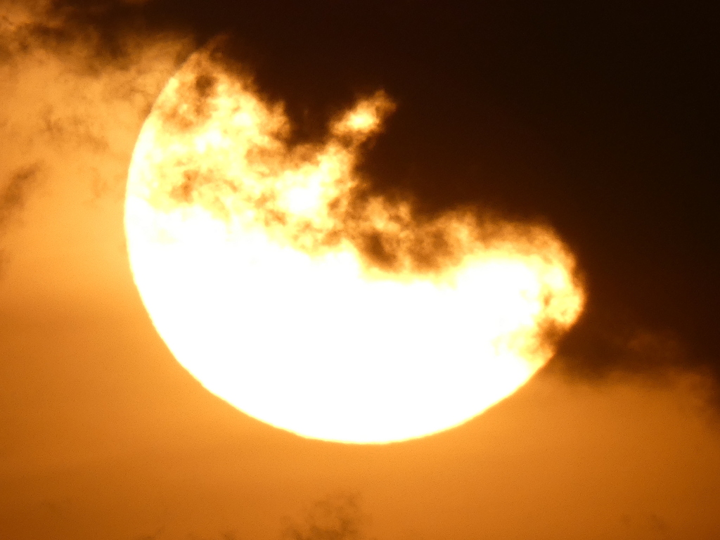 クロ雲の下から大きな夕日