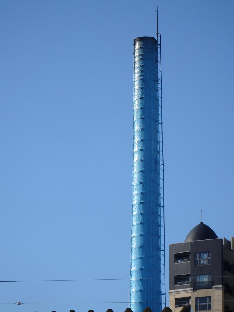 葛飾区立石の青い煙突と変わった建物の風景