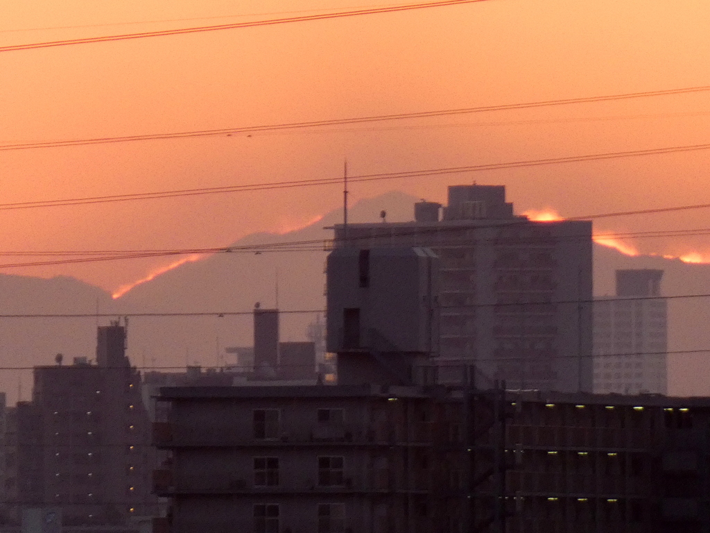 日が落ちた後のビルの後ろの景信山