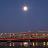 荒川土手の高速高架上の明け方の満月