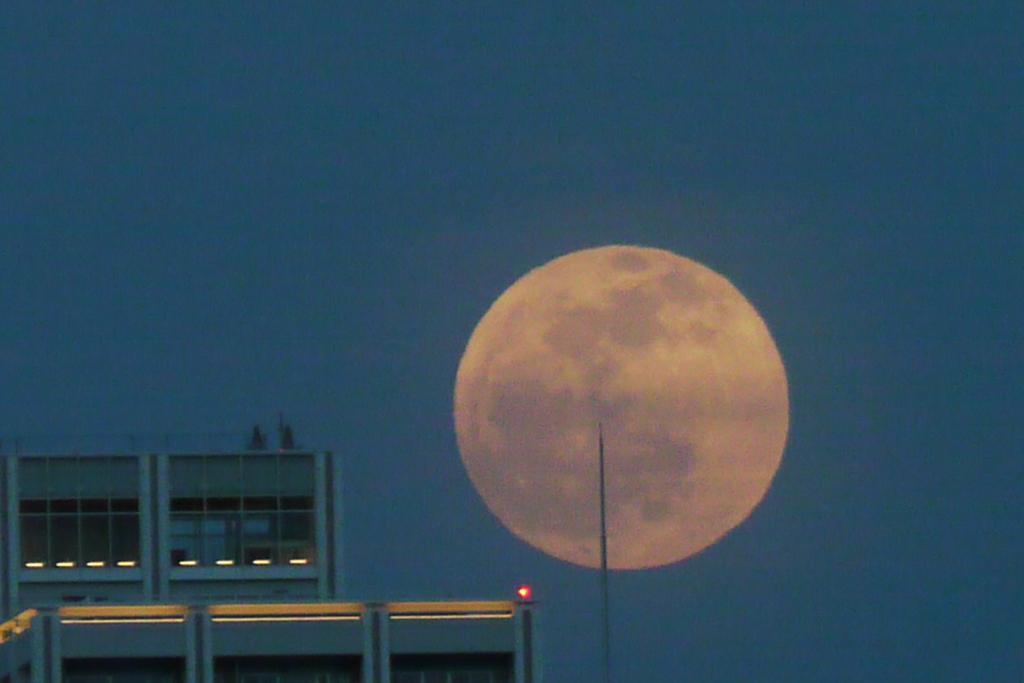 隅田川の夕日の反対側から雲被る満月