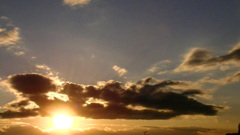 荒川土手から夕日の上の寝そべるような黒い雲