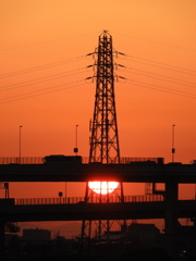 荒川土手から高速道路の後ろの鉄塔の夕日とその左下の埼玉の笠山
