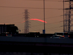 千住新橋から高速上の遠くの鉄塔右の丸山に落ちる夕日