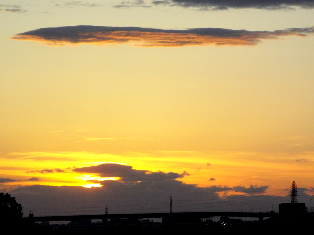 舎人ライナーの高架上雲間に落ちる夕日と行焼け雲のサンセット