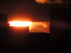 大室山に雲間からの大きい夕日限られた空間の世界に