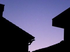 路地の間の紫の夕空に木星