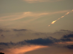 遠くの金色に光る飛行機雲