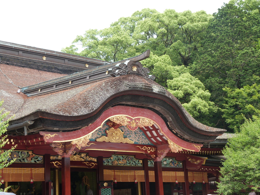大宰府天満宮の屋根の彫刻とバックの緑が