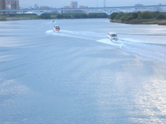 荒川の薄青いシルク水面の三艘のクルーザー