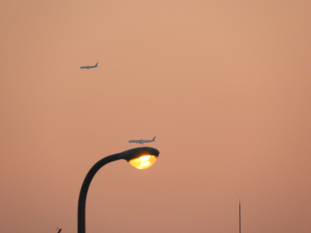 夕方の街路灯の上の2機の飛行機
