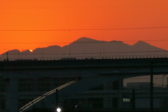 裾の夕日の一部の残る舎人高架上の大持山の夕焼け
