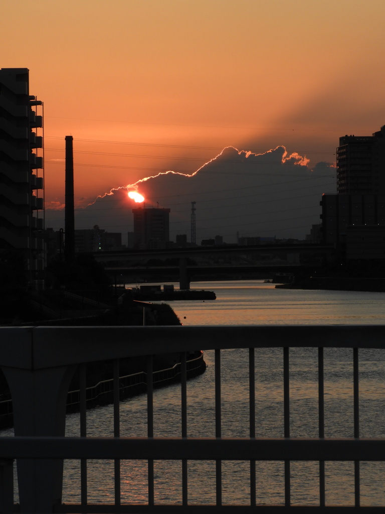 隅田川尾竹橋の先の雲に落ちる夕日