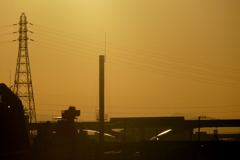 隅田川の夕日の下の鉄塔と煙突と舎人ライナーの移動