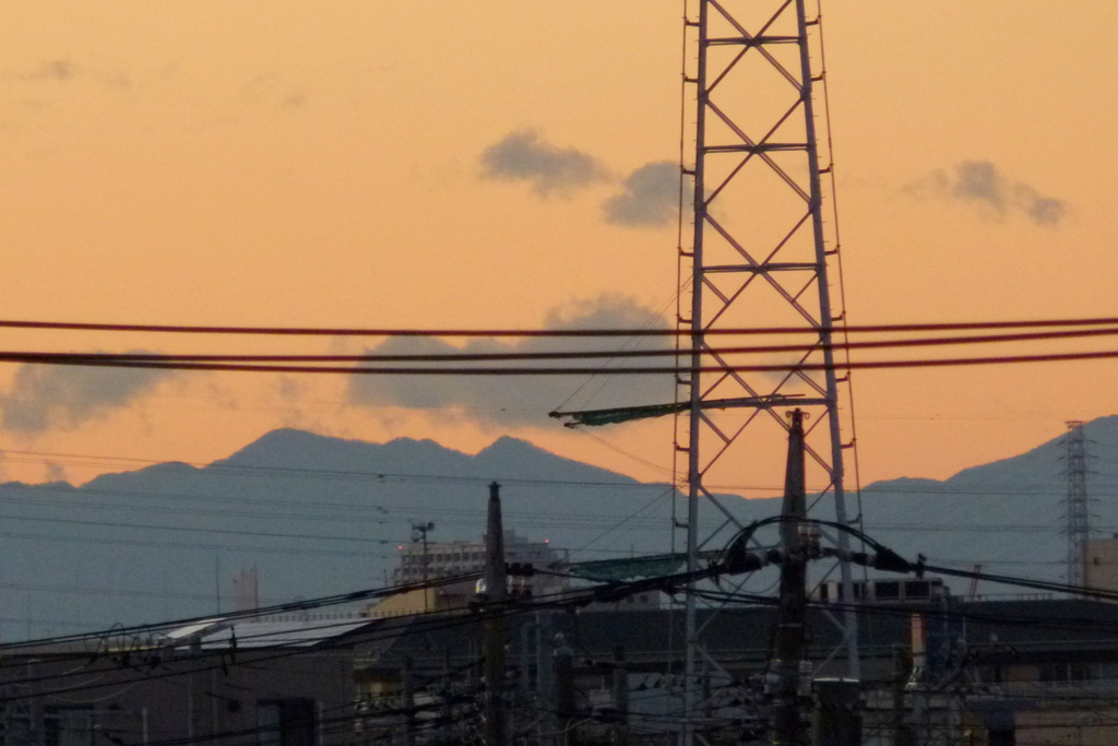 荒川土手の高速下の大持山小持山の夕日のシルエット