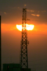 雲から再び顔を出す鉄塔の夕日