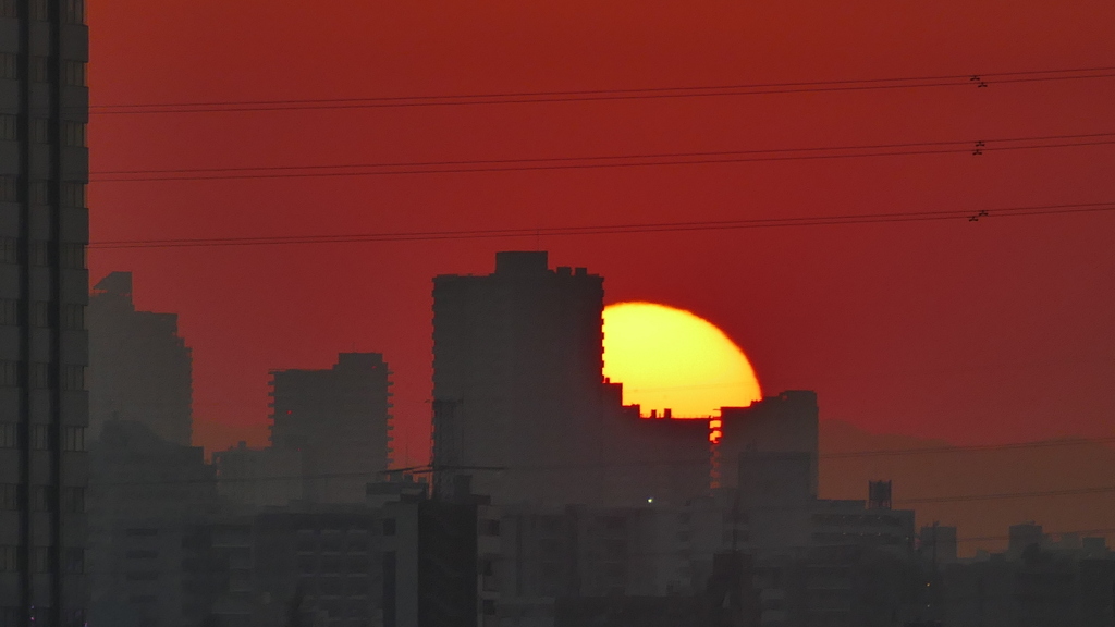 西新井橋からビルの後ろの菜畑山の夕日