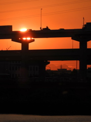 荒川土手から高速道路の下の東御荷鉾山と上の夕日