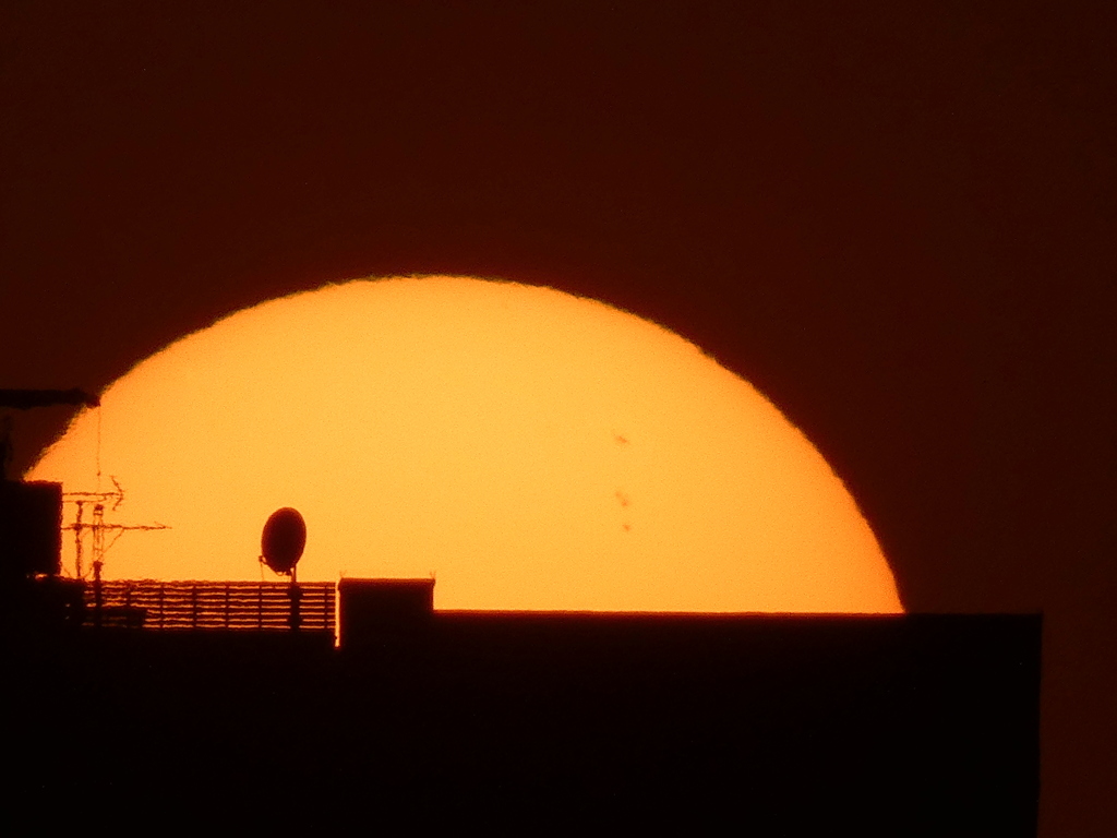 マンションの屋上の大きな夕日