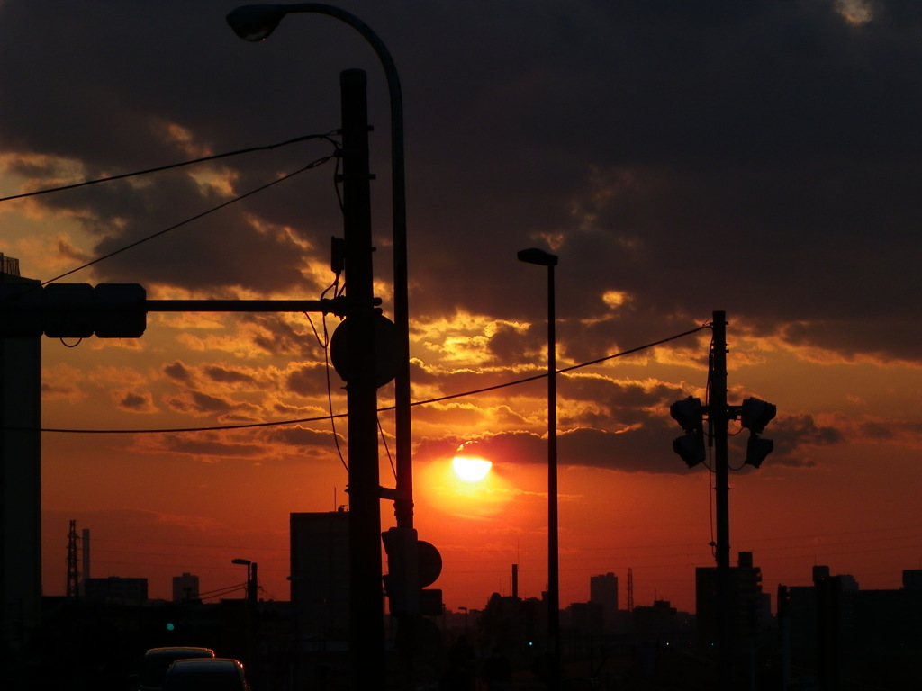 西新井橋の交差点の黒雲下の夕日