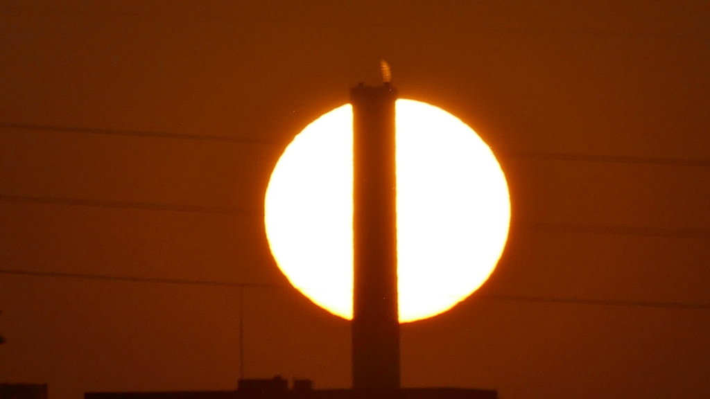 巨大煙突の後ろの夕日