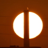 巨大煙突の後ろの夕日