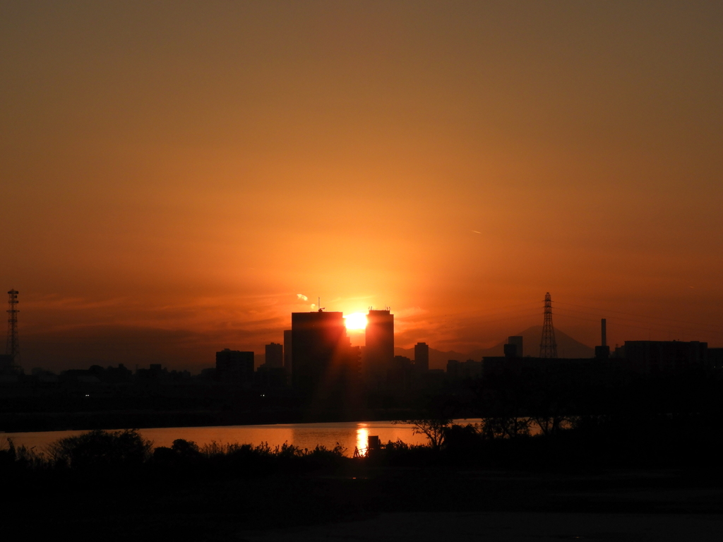 荒川のタワービルの間の夕日