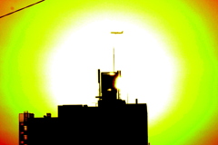 千住土手下通りのマンションの夕日の中の飛行機