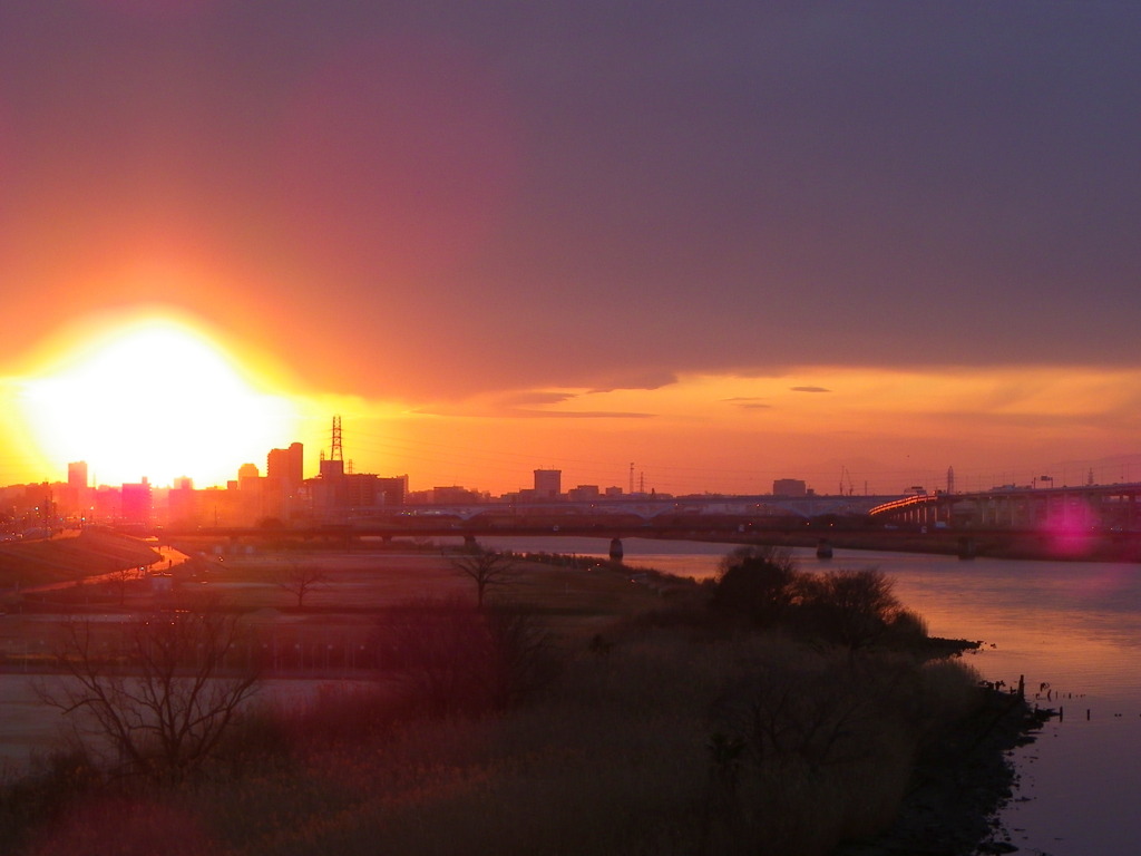大きな黒雲の下の千住新橋からの夕日