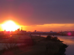 大きな黒雲の下の千住新橋からの夕日