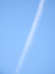 千住東の大踏切上空の飛行機雲に飛行機