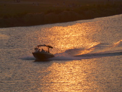 夕日を浴びる荒川の小型のクルーザー