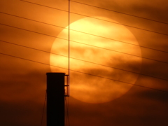 煙突と雲被る夕日