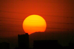 大蔵高丸の左縁のベールを被った夕日