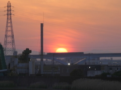 落日直前の夕日の前を舎人ライナー