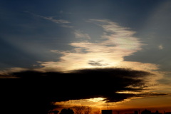 荒川土手から西の夕日のかぶさる黒雲とその上の夕方彩雲