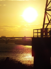 河原の鉄塔脇の夕日